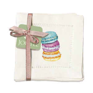 set of 6 cloth napkins with stack of three macarons. colorful designs on off white napkin