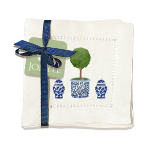 cloth cocktail napkins with two ginger jars and a topiary plant in the center in a blue and white ginger jar
