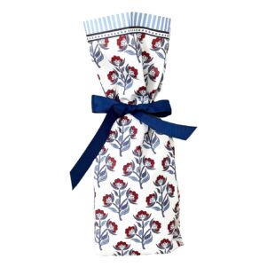 white paper gift bag with a red and blue floral print all over tied with a blue ribbon